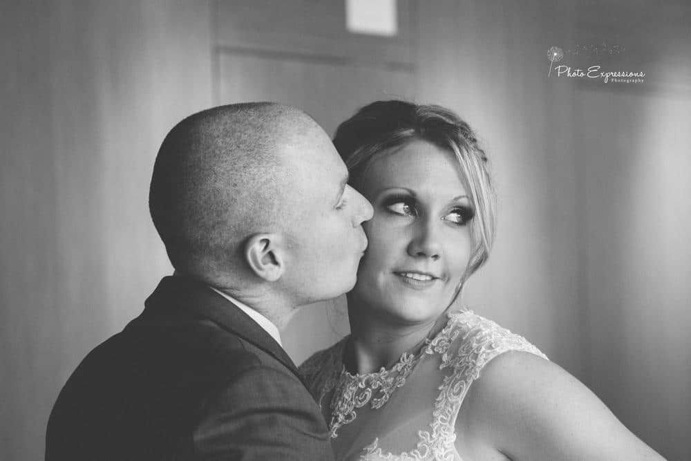 Black and white portrait of newlyweds sharing an intimate moment.