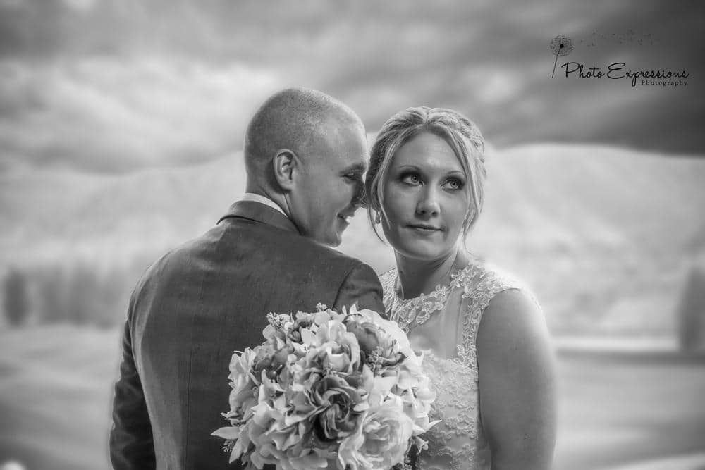 Couple posing for dramatic black and white wedding portraits outdoors.