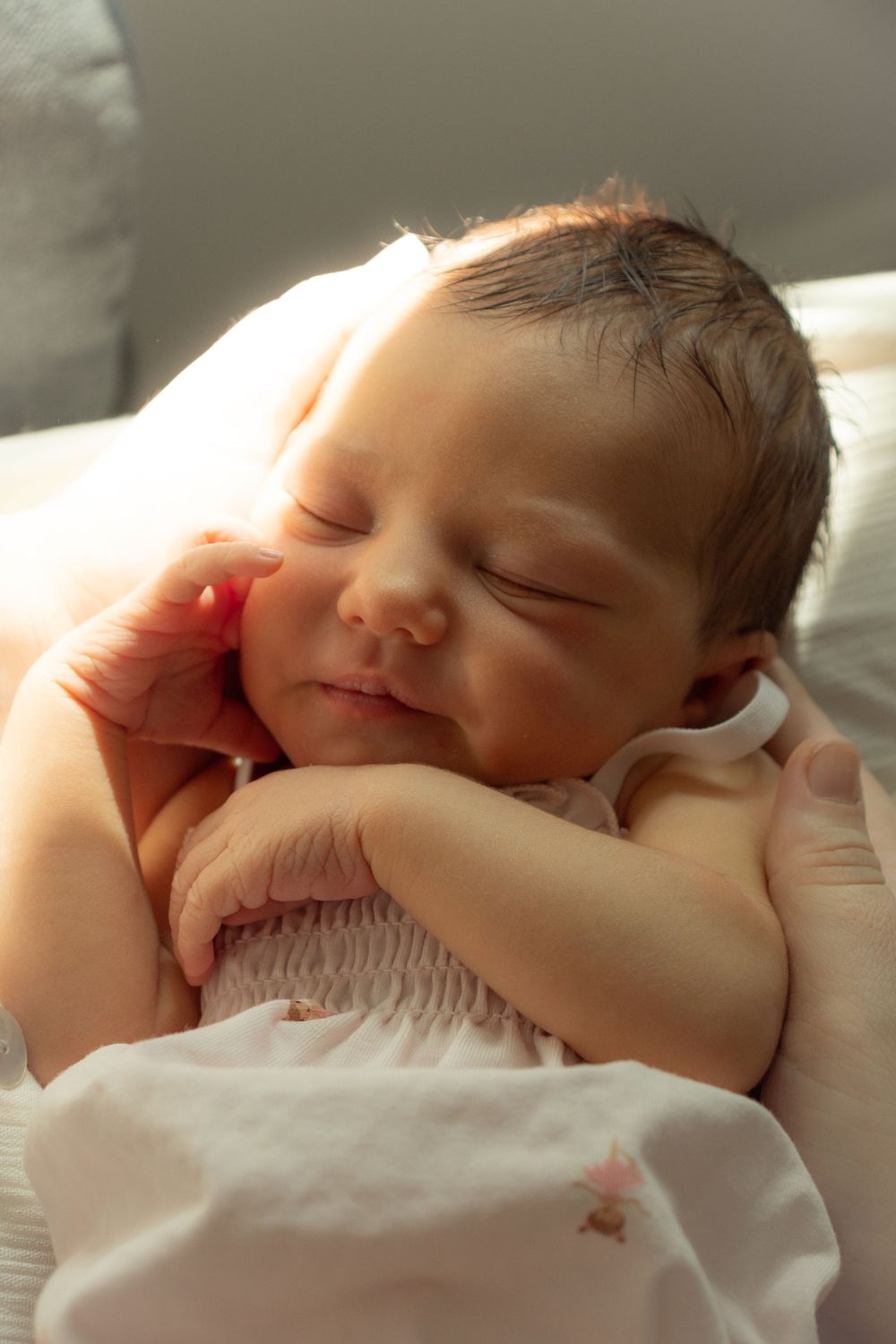 Sweet sleeping newborn baby captured in soft natural window light.