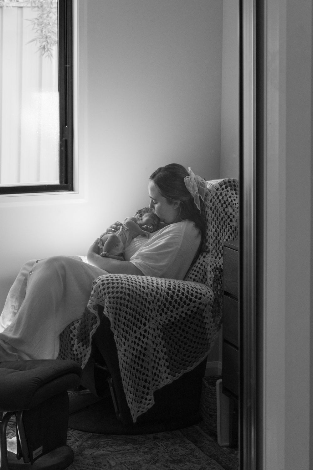Serene black and white photos showing quiet moments of new mum and daughter in a cozy chair.