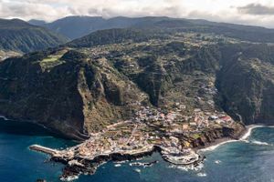 Coastal town nestled on a dramatic clifftop overlooking the deep blue ocean waters.