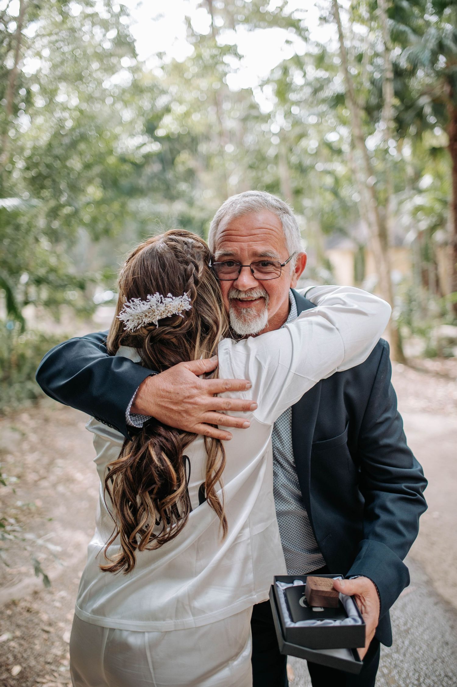 An emotional moment shared during a wedding day embrace outdoors.