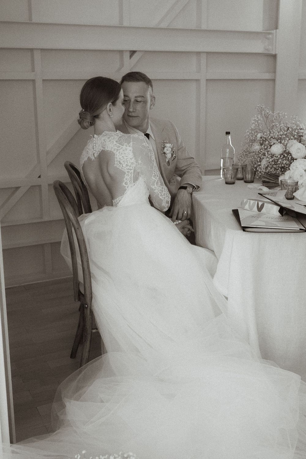 Sequence of a bride in a flowing white gown sitting at a dining table during a wedding reception.