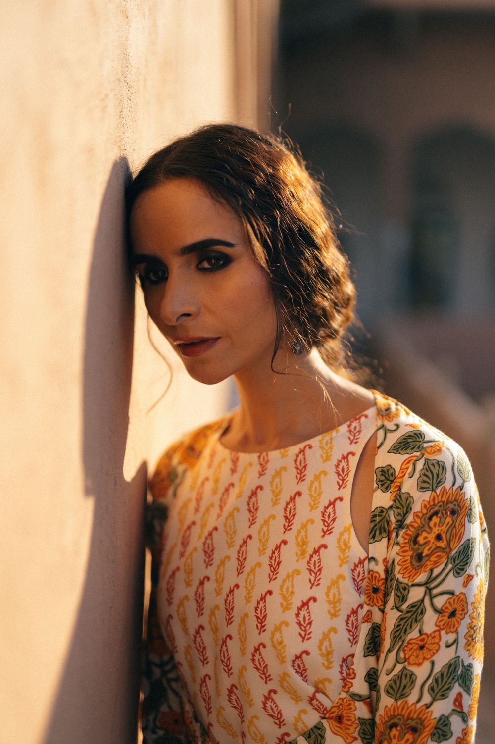 Fashion portrait featuring ornate dress with musical note pattern and floral design in warm sunset lighting.