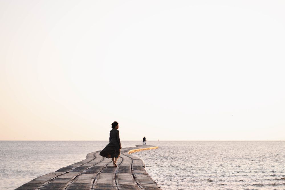 Vrouw in beeld. Zee. Strand. Beweging. Creatief portret.