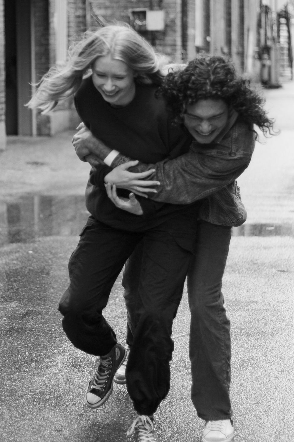 Couples photography of a man and woman playfully walking down the street.