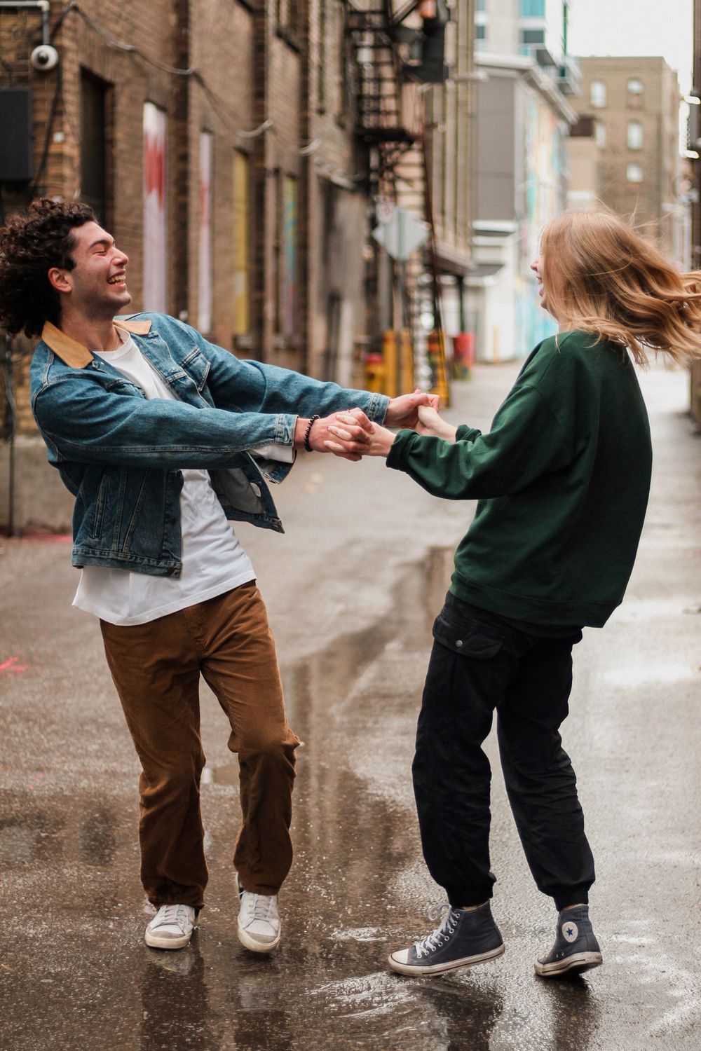 Couples photography of a man and a woman holding each other and spinning in a circle.