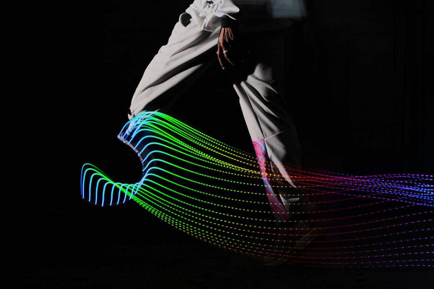 personne amputée qui marche dans le noir avec un prothèse luminescente. Lightpainting avec un athlète Salomon