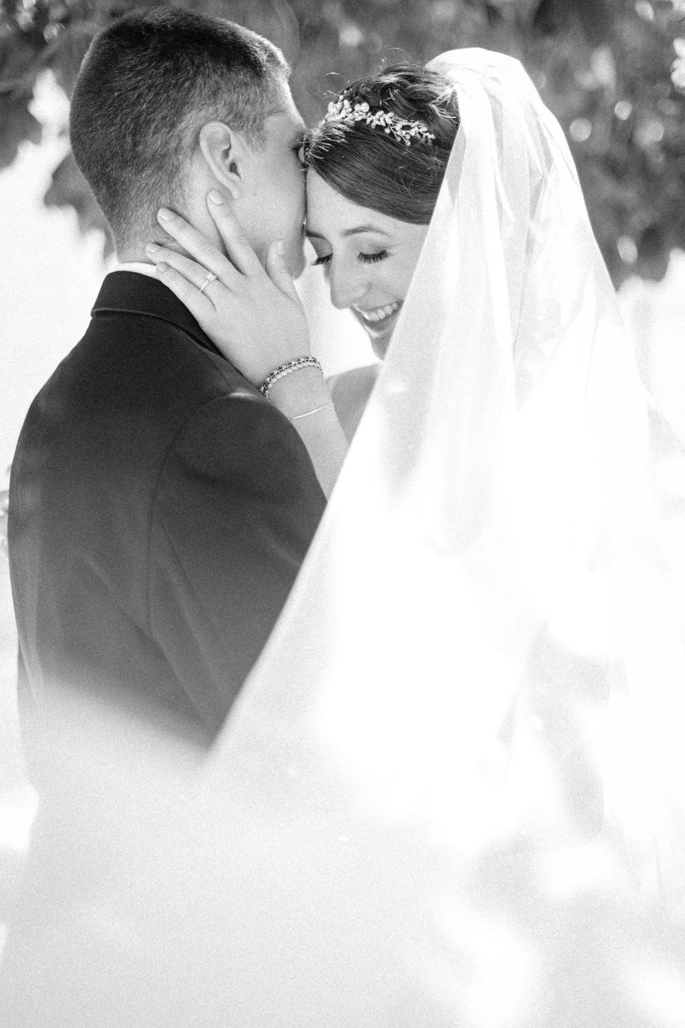Black and white intimate wedding portraits captured under tree canopy.