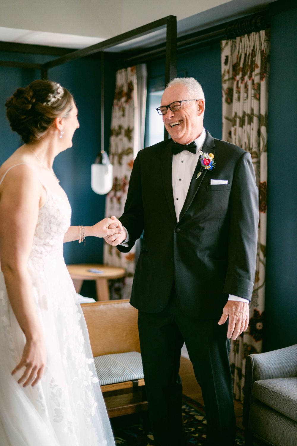 First look moment in a hotel room as two people share an emotional reaction during a wedding day.