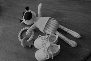Collection of plush toys and baby items in black and white.