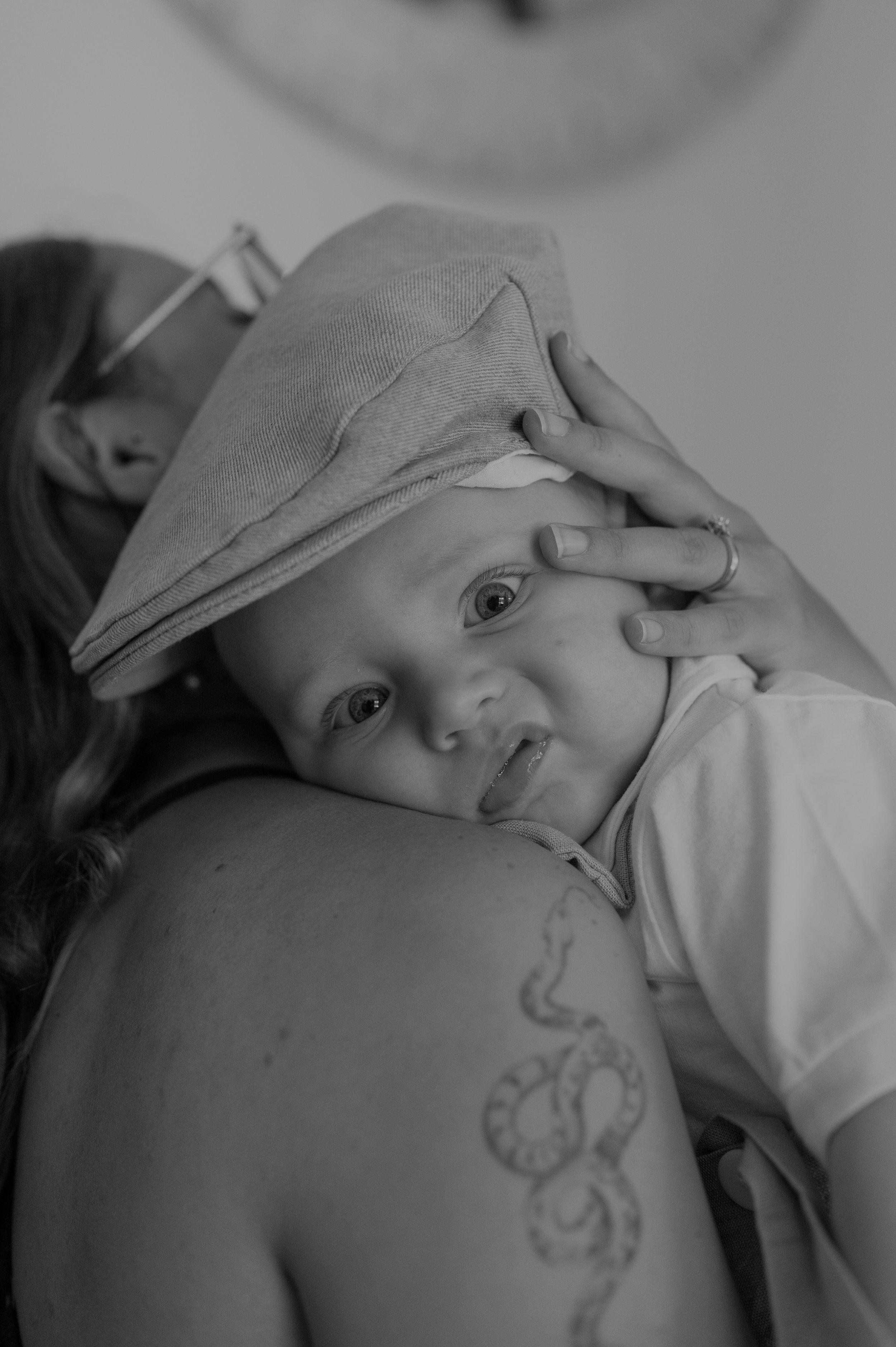 Black and white image showing intimate parental bonding moment with baby.