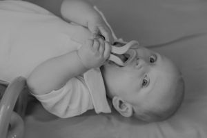 Black and white portrait of baby lying down.