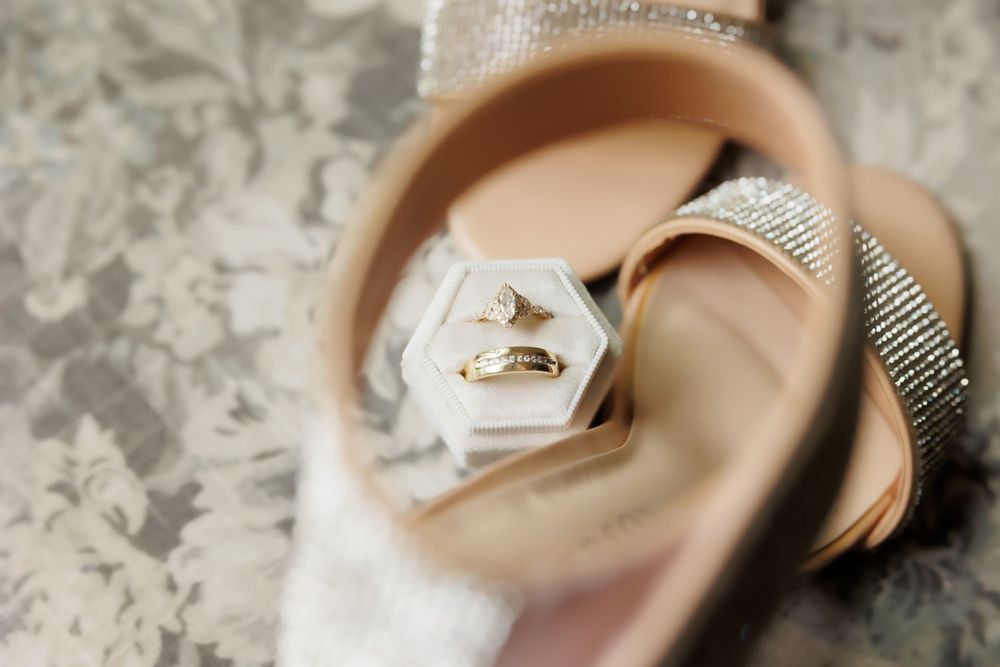 Wedding rings photographed through a reflection with artistic bokeh effect.