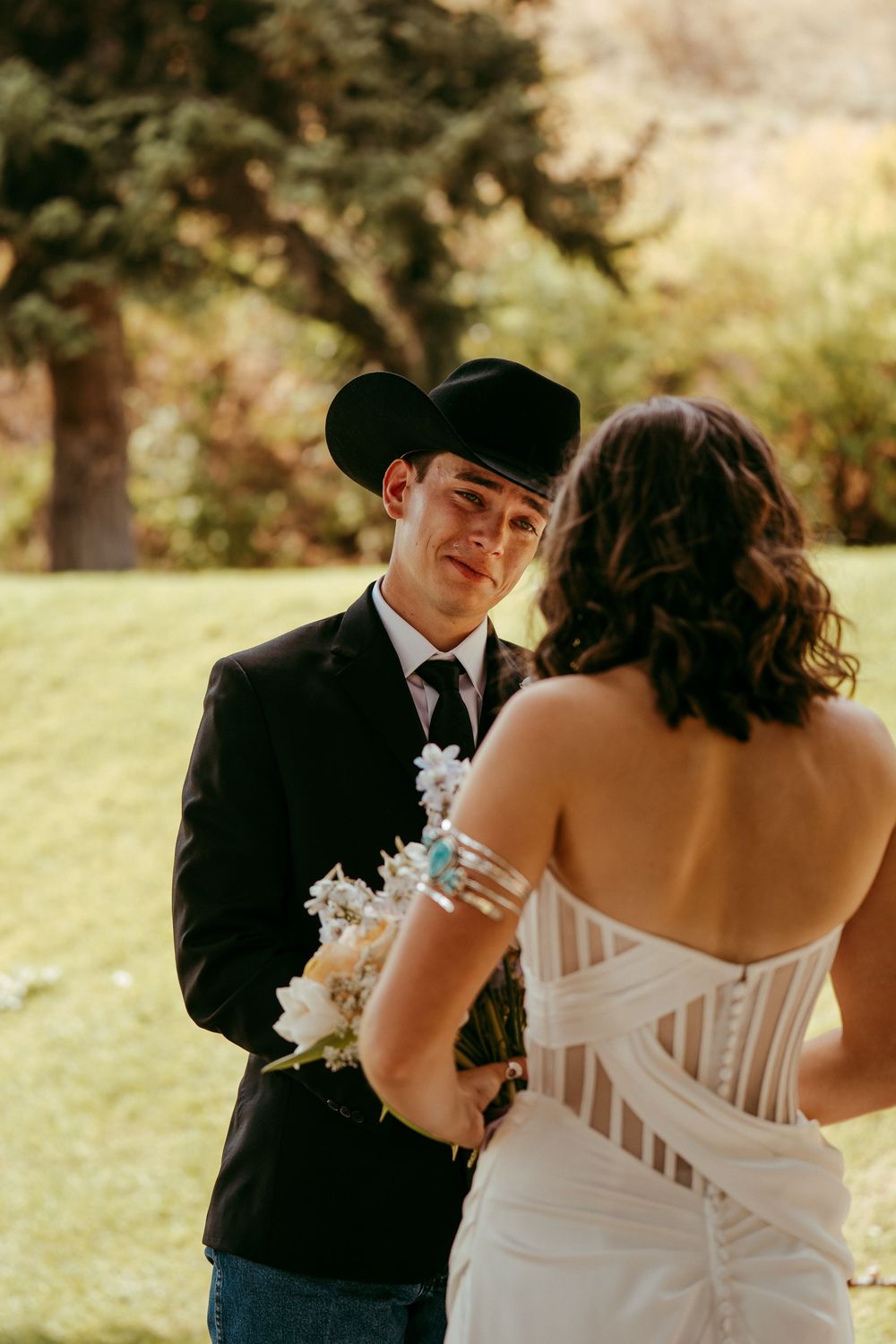 romantic western wedding portrait of a bride and groom embracing at sunset in the mountains