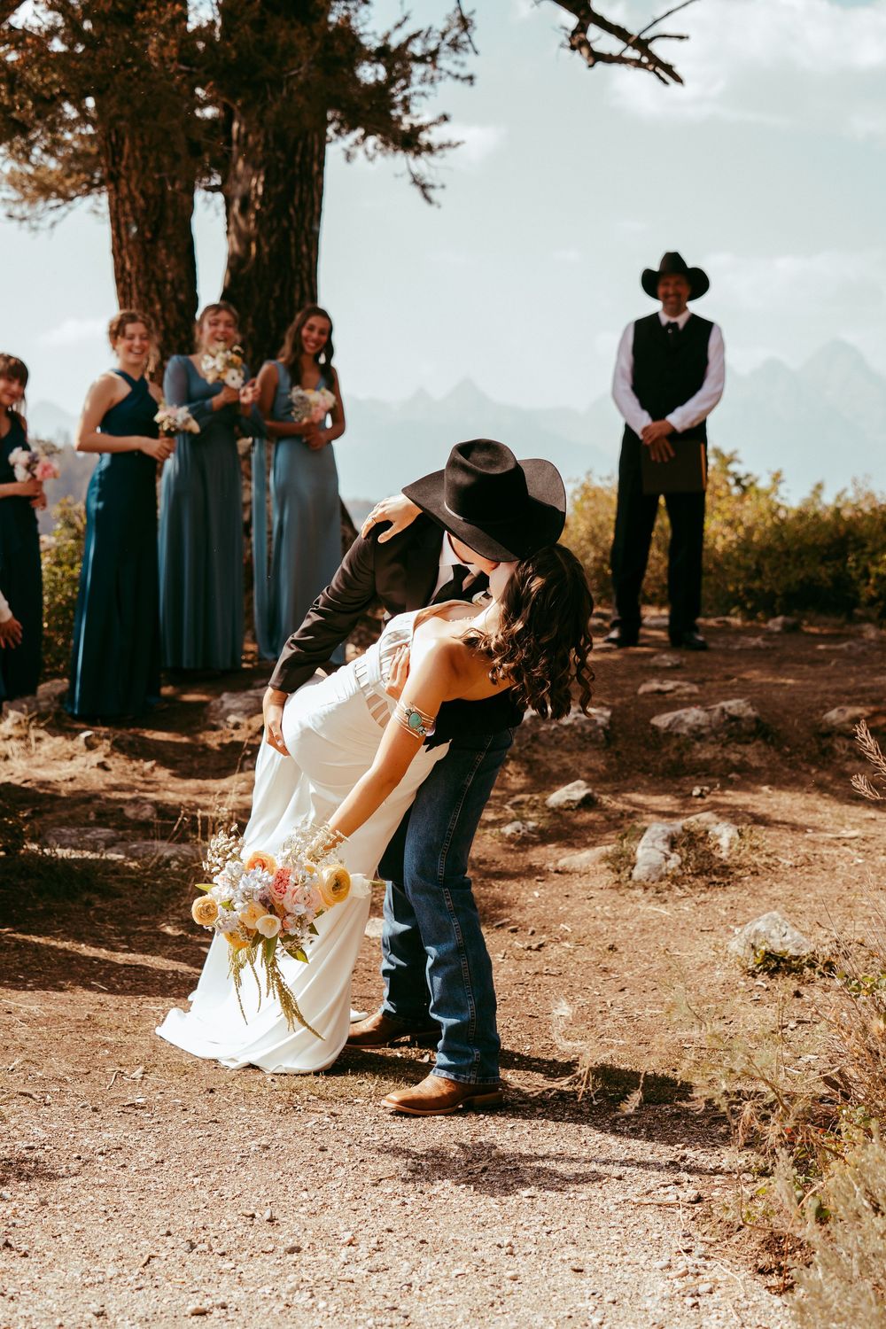 romantic western wedding portrait of a bride and groom embracing at sunset in the mountains