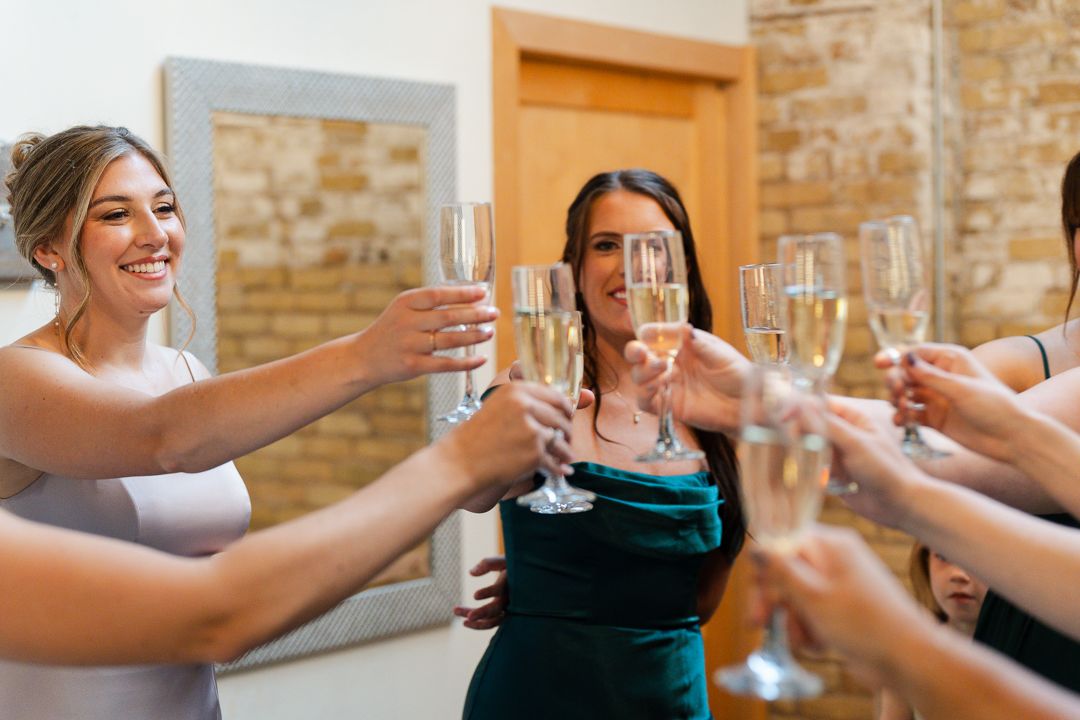 A couple sitting at a sweetheart table about to kiss on their wedding day at the Schnepf Farms Wedding Venue.