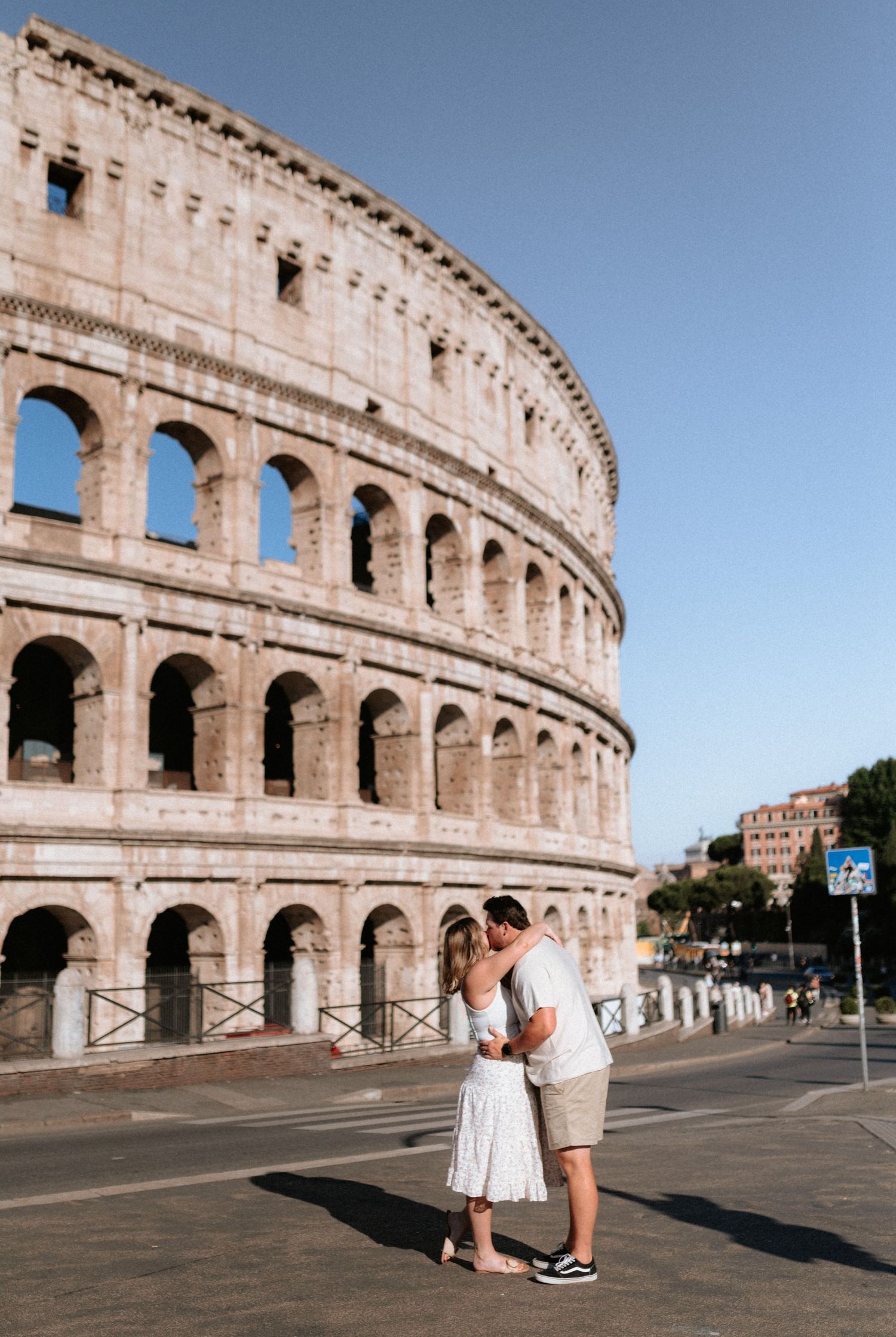 Romantic moment captured in front of the historic Colosseum in Rome.