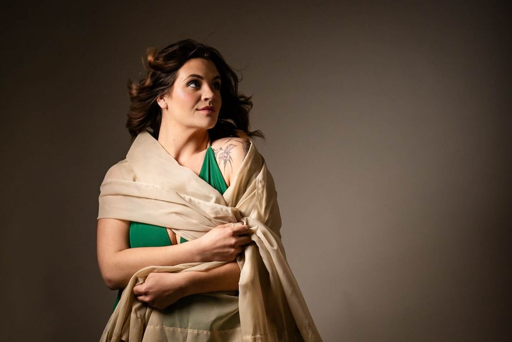 Fine art portrait of a woman draped in green and gold fabric during a studio session in Mountain Home, Arkansas