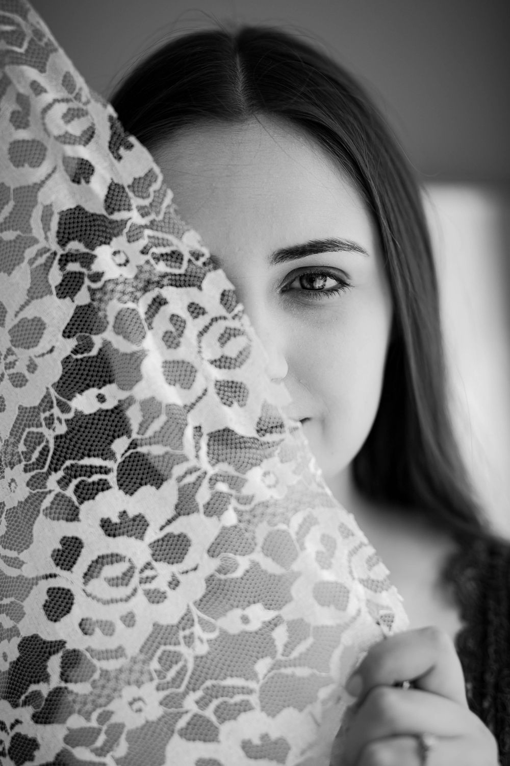 Black-and-white fine art portrait of a young woman with a lace veil during a studio session in Mountain Home, Arkansas