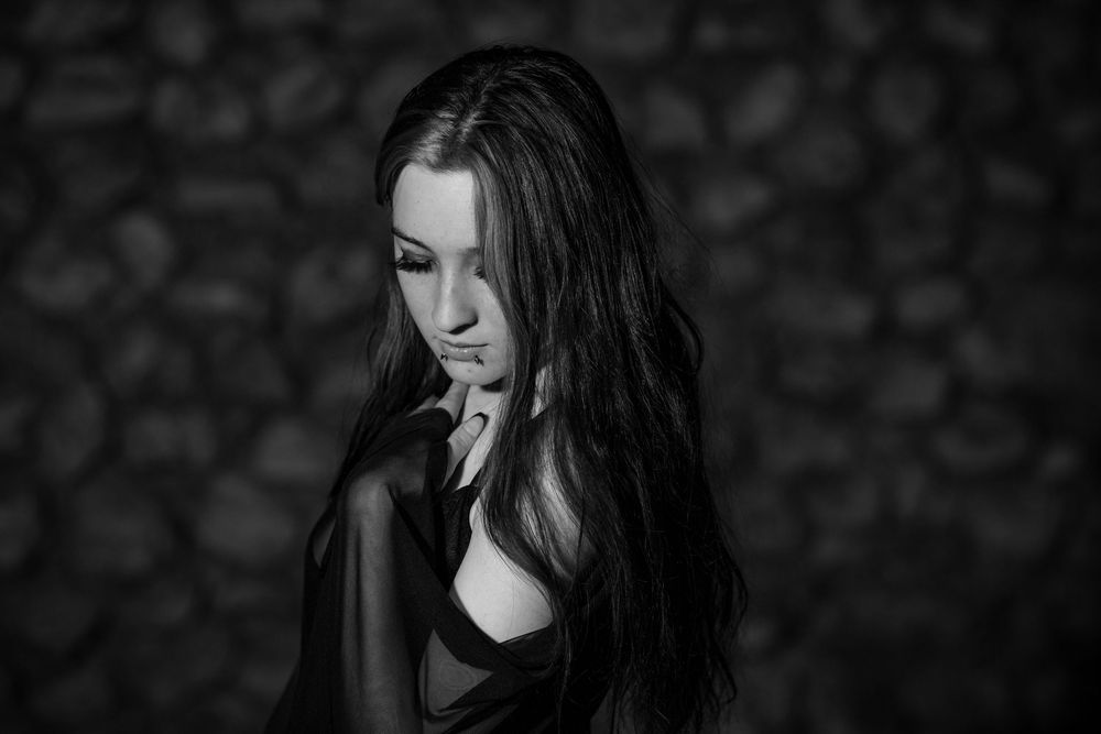 Black-and-white creative portrait of a young woman during an outdoor session in downtown Mountain Home, Arkansas