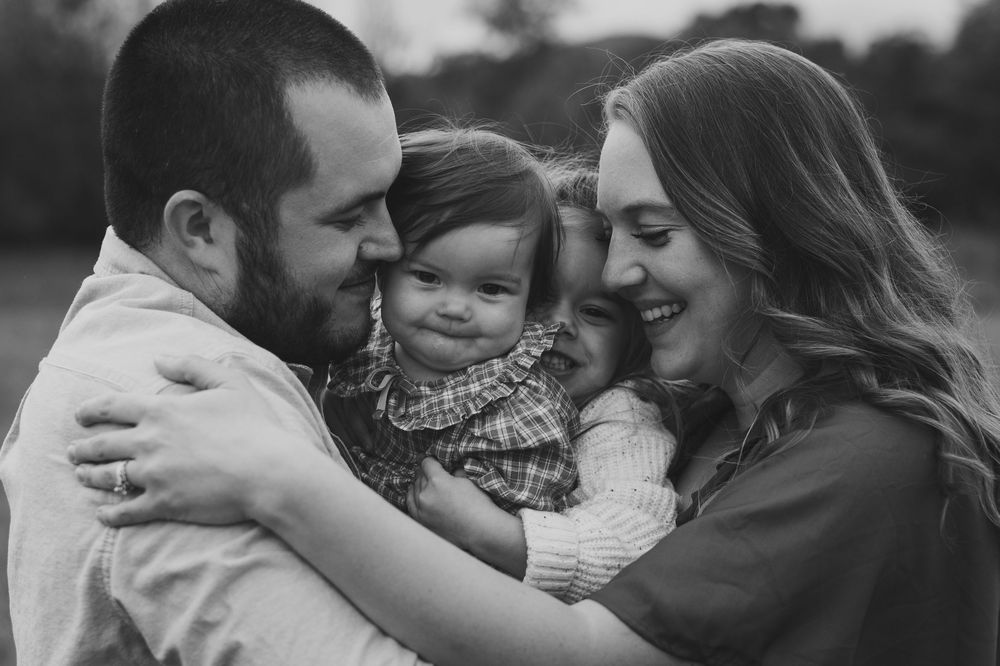 Black and white of family laughing in a group hug