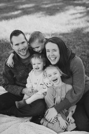 Black and white of family laughing in a group hug
