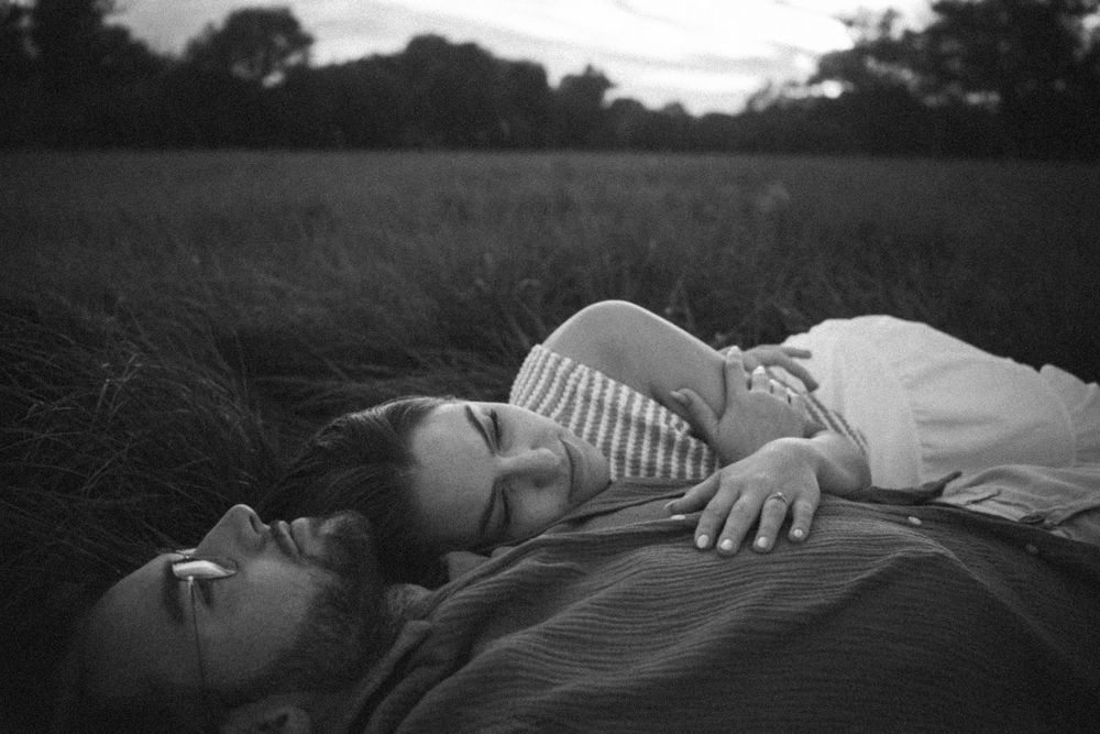 A series of black and white photographs showing someone lying down in different positions on a grassy surface.