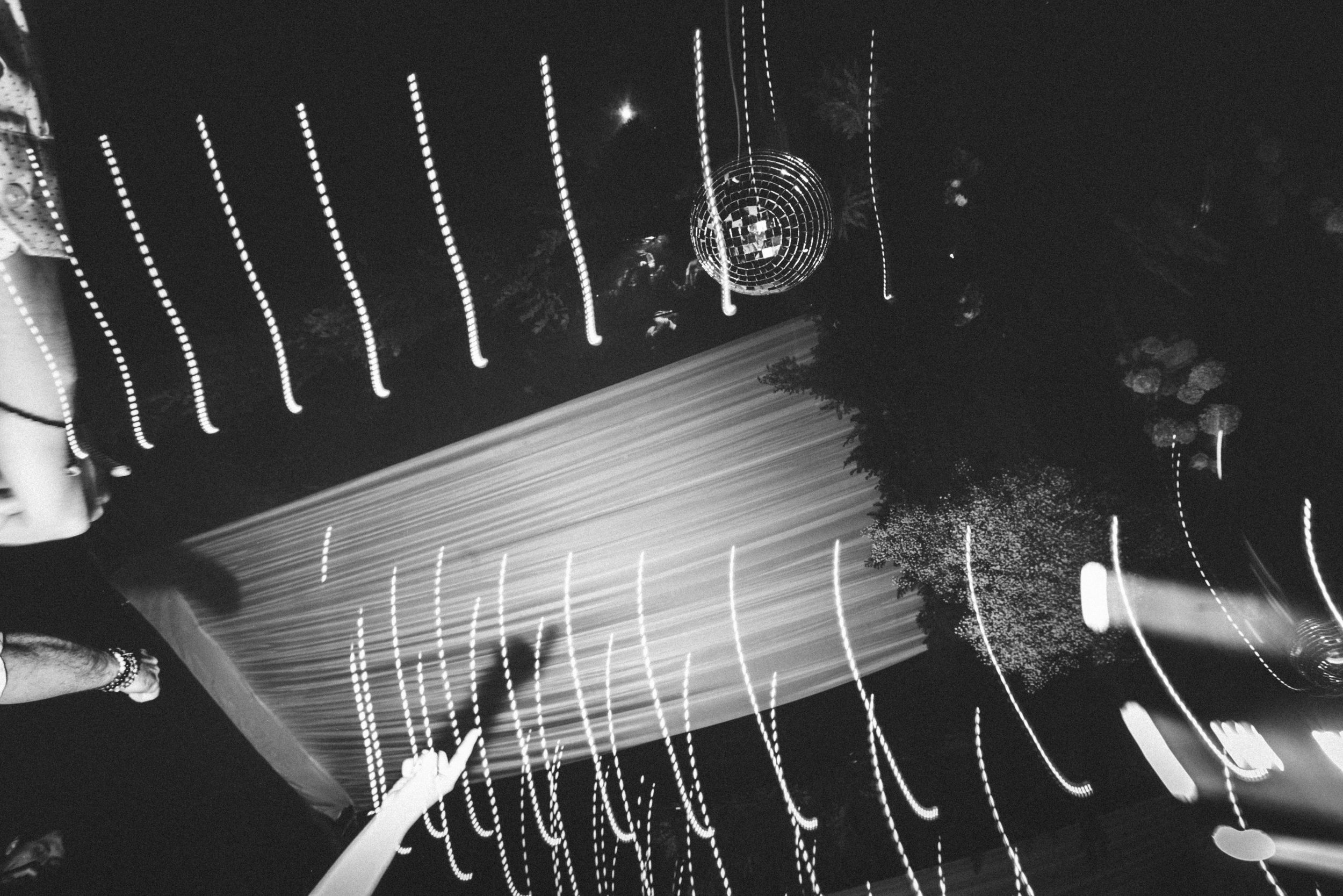 Close-up black and white photo of electric guitar strings and fretboard showing detailed texture and patterns.