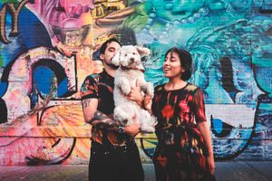 A group of friends enjoy a casual moment together against a vibrant graffiti wall with colorful street art.