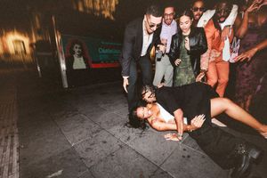 People dancing and socializing at a dimly lit nightclub or party venue with atmospheric lighting.