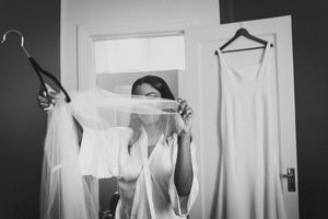 Four black and white images showing white clothing items being held up against a dark background.