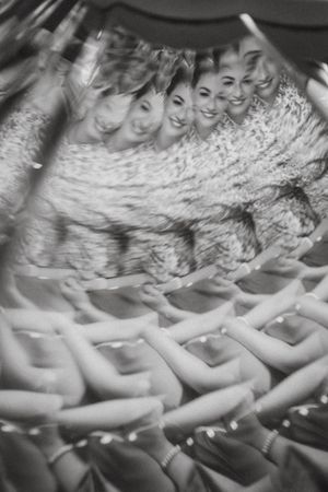 Black and white vintage photograph showing a synchronized swimming performance with multiple swimmers in formation.