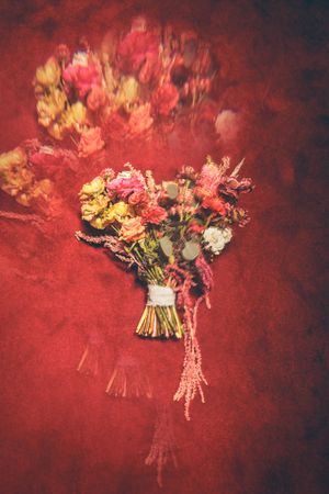 A sequence of floral bouquets with yellow and pink blooms arranged against a deep red textured background.