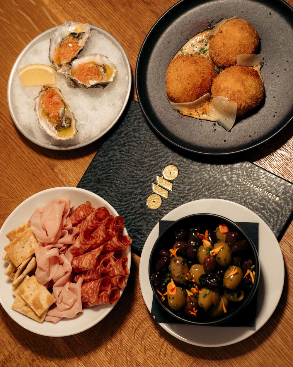 Overhead view of oysters, arancini, charcuterie, and marinated olives on a wooden table at Otto restaurant.

Vancouver Canada Scene