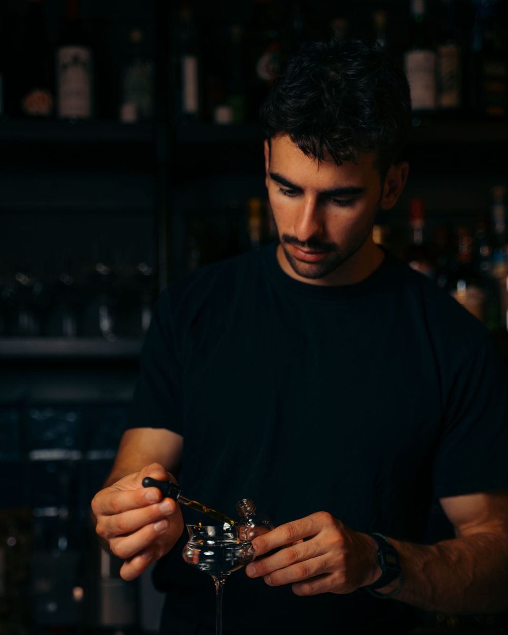 Focused bartender in black t-shirt carefully garnishing a cocktail in a dimly lit bar.

Vancouver Scene