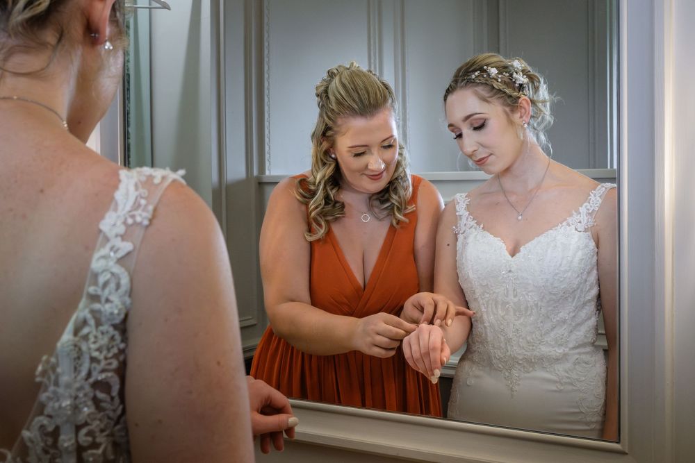 Bridesmaid helping bride with her bracelet at Merewood Country House Hotel