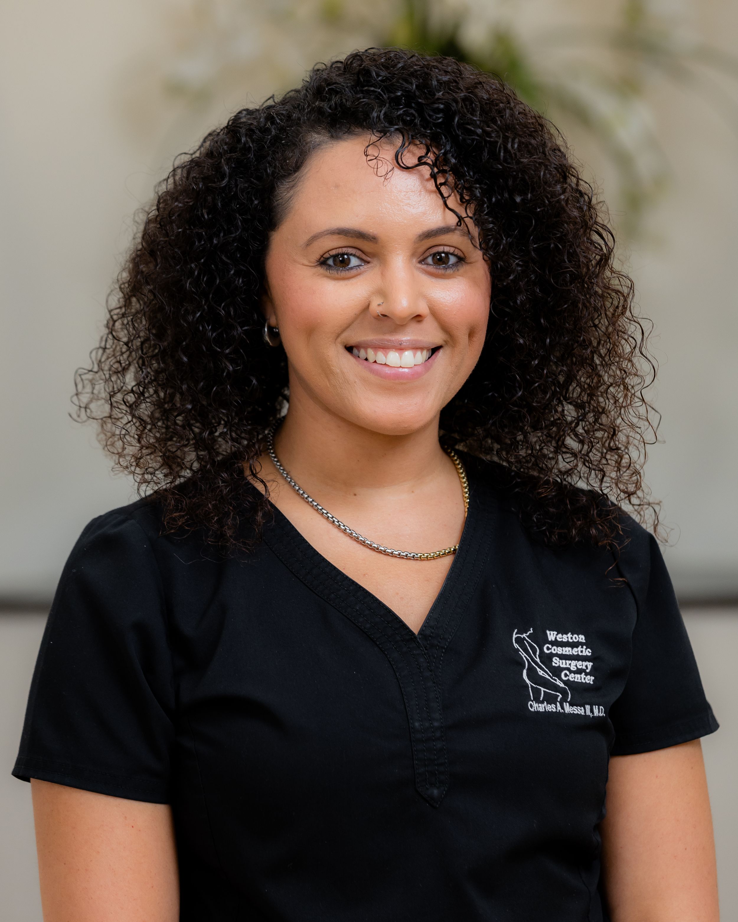 Progressive headshots showing someone with natural curly hair wearing black scrubs against a light wall.
