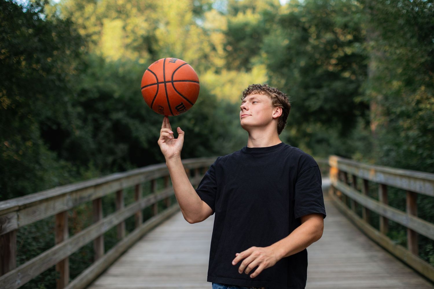 Senior boy photo with basketball; outdoor, natural light senior guy pictures by Brighton, MI portrait photographer