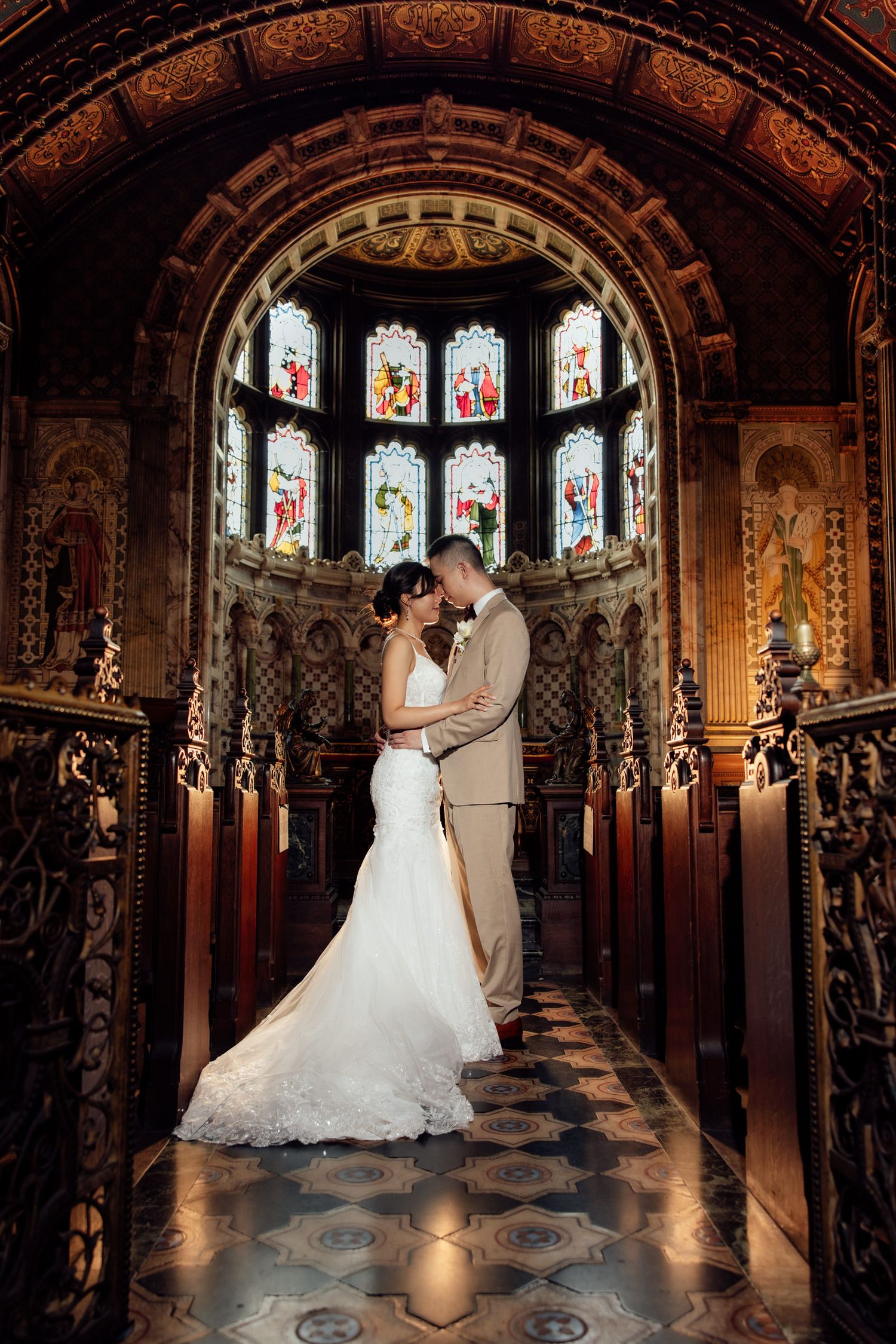 Black and white photo of a smiling bride and groom exchanging vows at an elegant wedding ceremony.