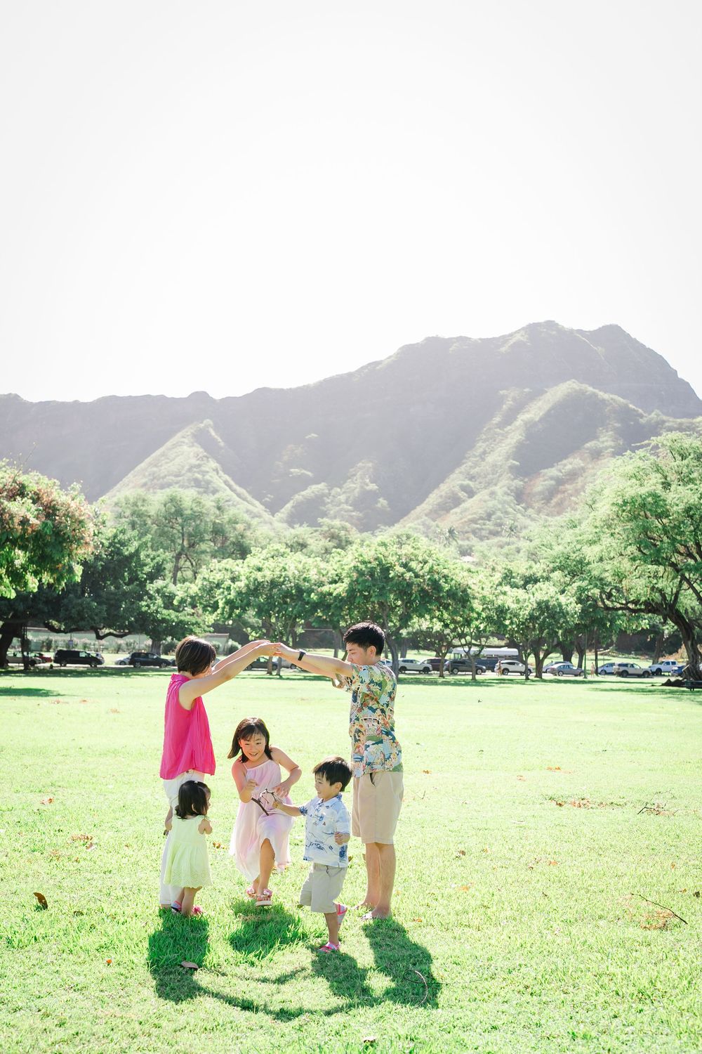 Family playing together with Diamond Head in the background during an Oahu family photography session in Honolulu, Hawaii