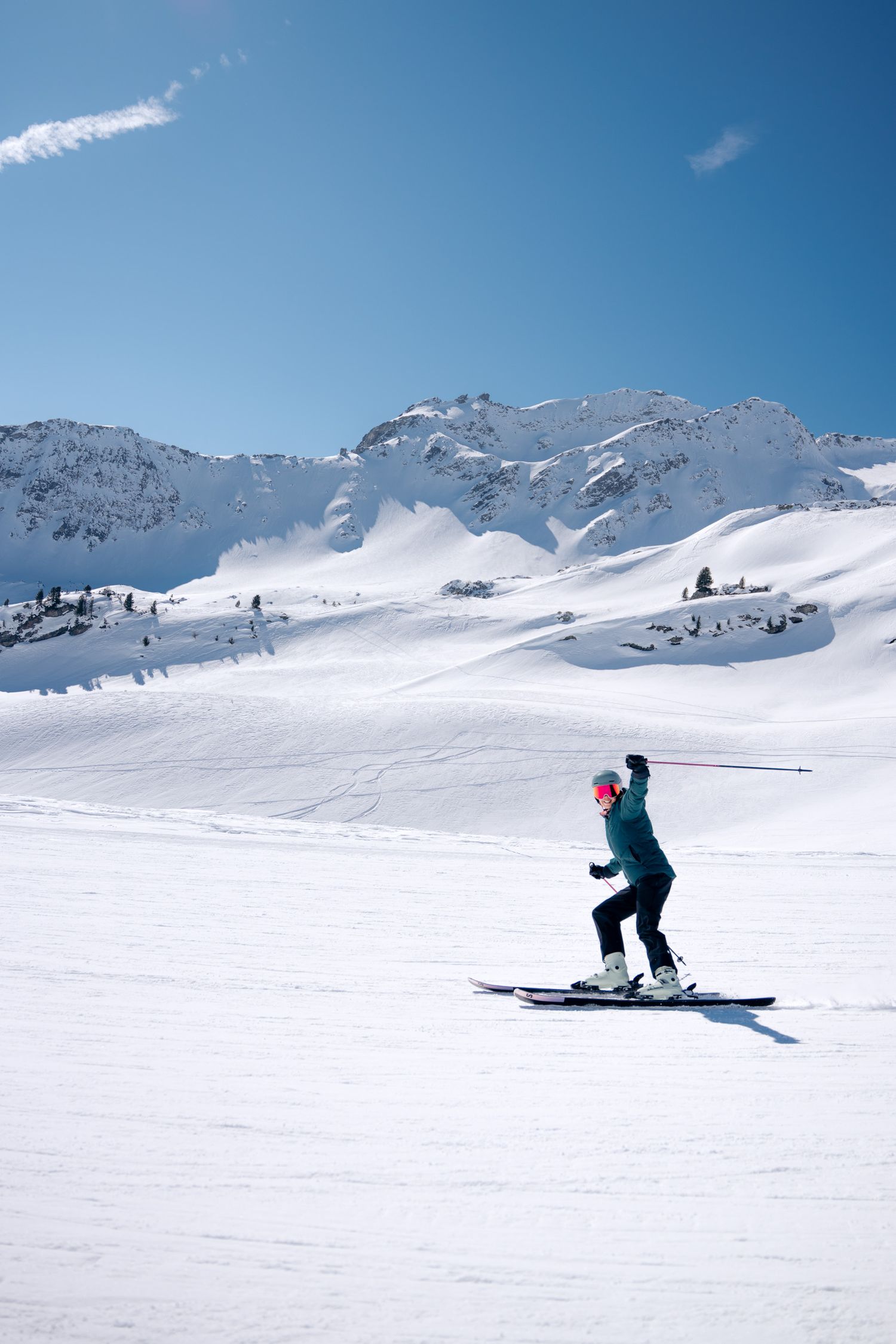 skieuse quie lève les bras sur le spistes de ski de la rosière