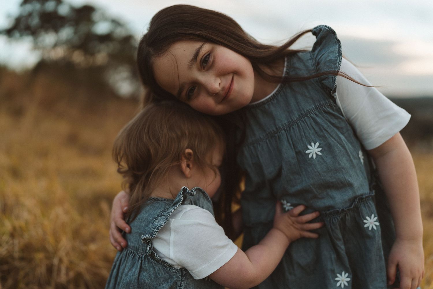 a young girl and her sister cuddle together