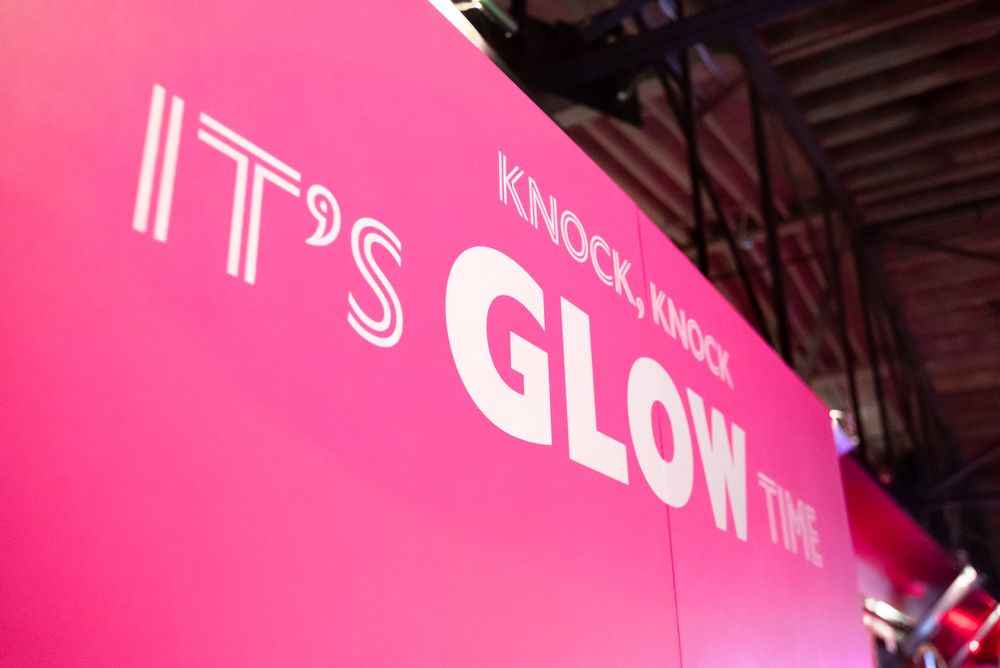 Bright pink wall with illuminated text reading 'It's Glow Time' in modern typography.