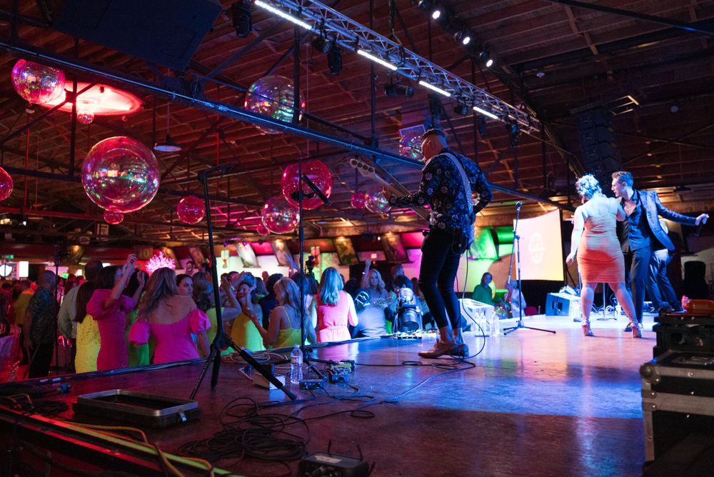 Dance floor scene with disco balls and colored lighting creating an energetic nightclub atmosphere.