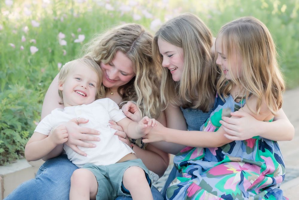 Candid moment of joyful laughter and embraces shared outdoors on a sunny day.