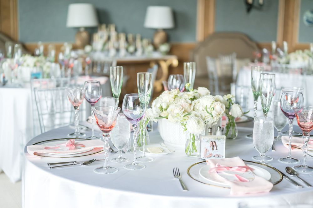 Elegant wedding reception table with pink and white place settings and floral centerpieces.
