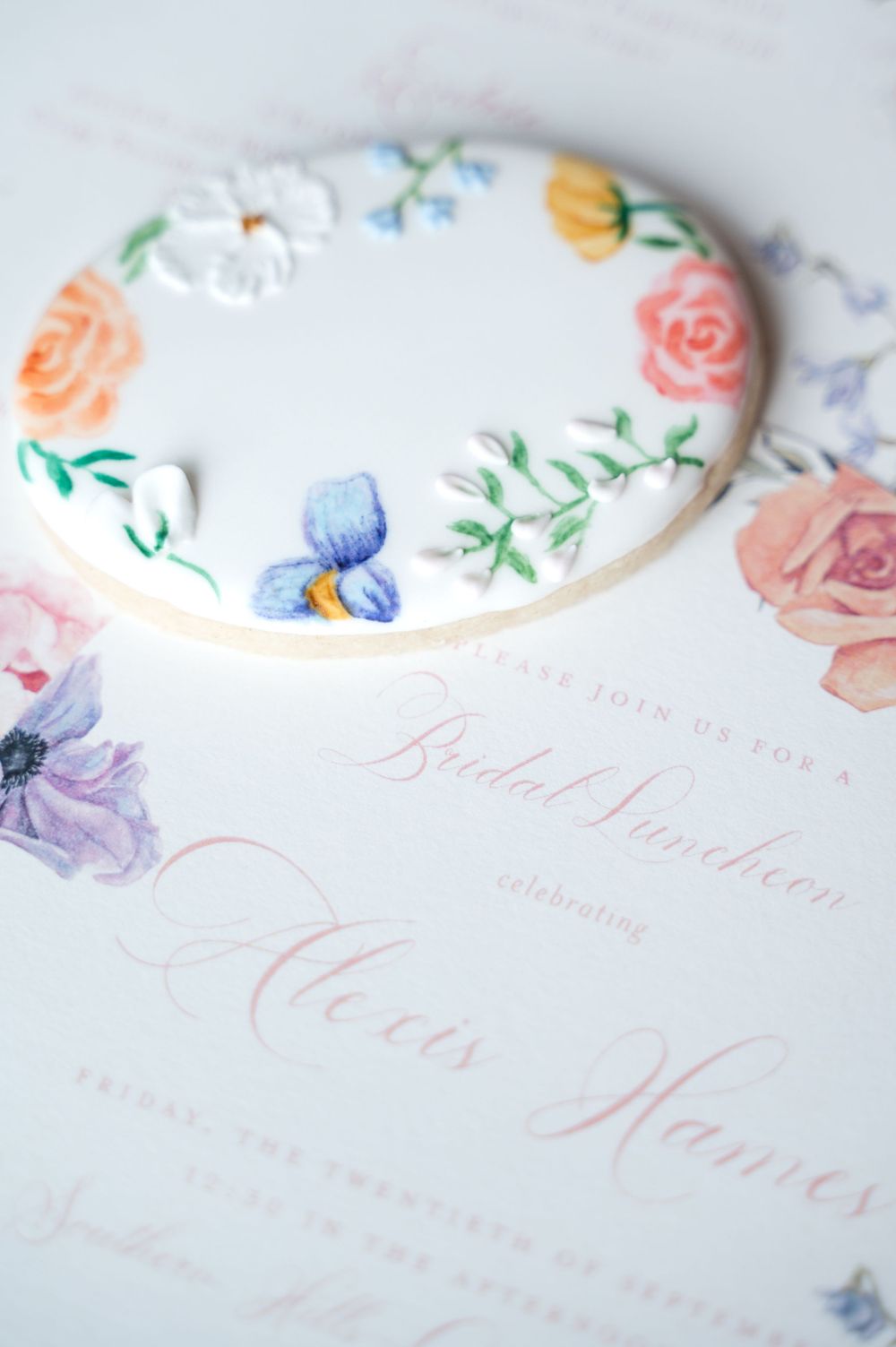 Elegant wedding invitation with delicate floral illustrations and watercolor details on white paper.