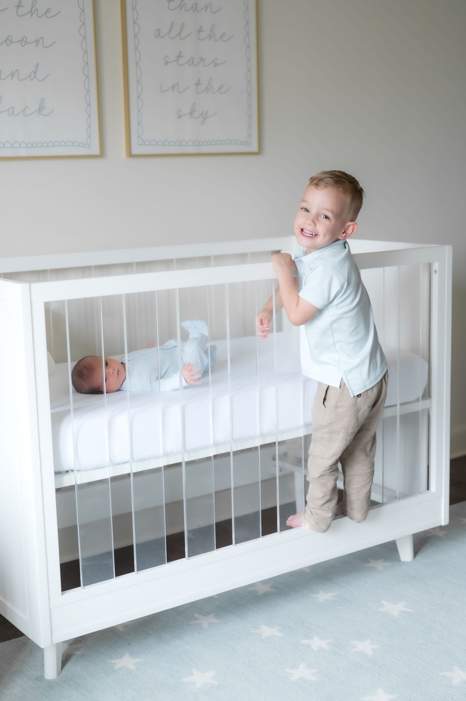 Couple with newborn baby reflected in round white pearl mirror in a bright nursery room.