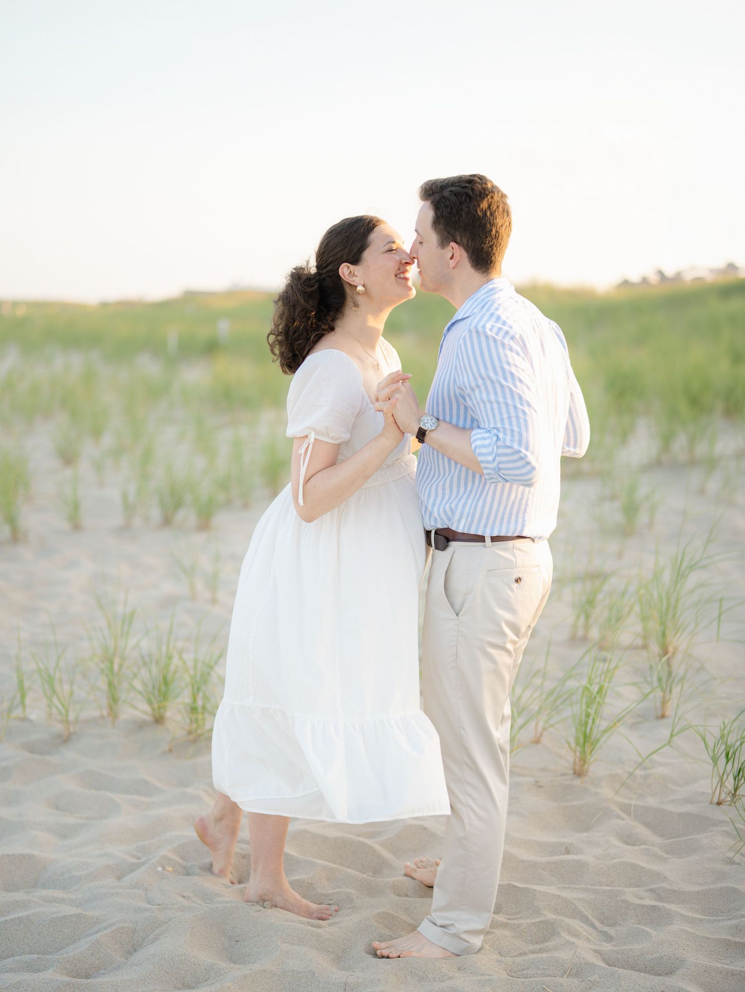 Young fun couple plays in the sand together on the beach near asbury park.